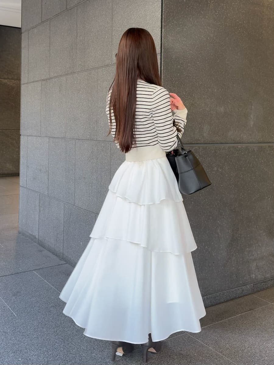 グレー系のブーツ、その他のワンピース、ブラック系のハンドバッグを着用したレディースの冬コーディネートの3枚目の写真