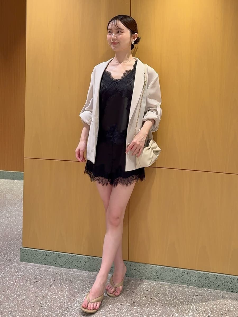 ホワイト系のテーラードジャケット、ブラック系のキャミソール、ブラック系のその他パンツを着用したレディースの夏コーディネートの4枚目の写真