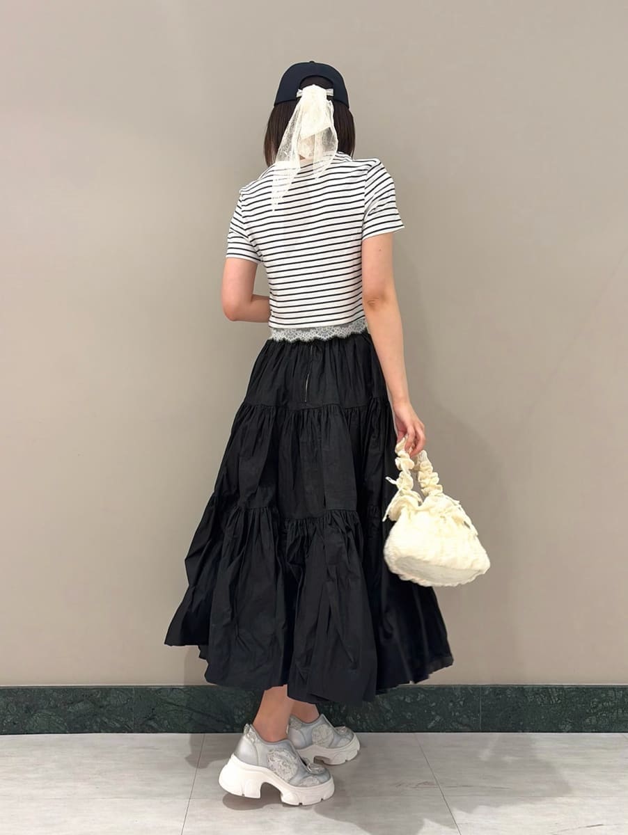 ブラック系のスカート、その他のTシャツ/カットソー、シルバー系のスニーカーを着用したレディースの春コーディネートの3枚目の写真