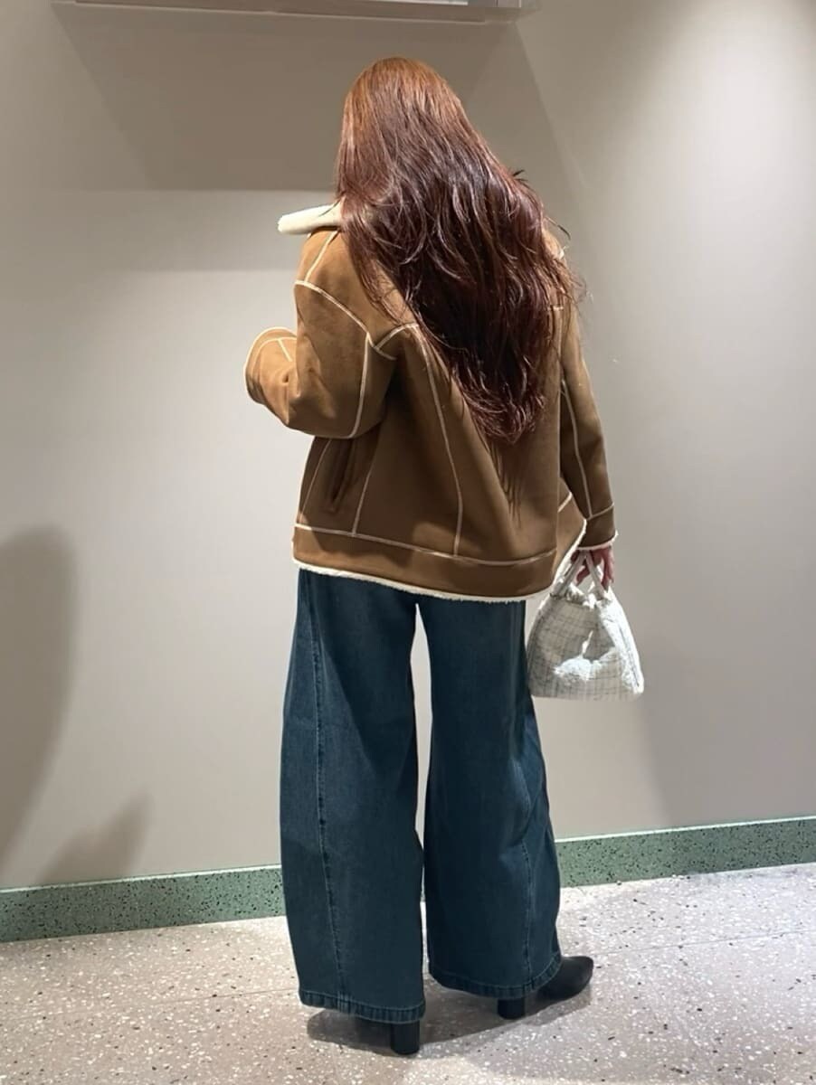 ブルー系のデニムパンツ、ブラウン系のニット/セーター、ブラック系のブーツを着用したレディースの秋コーディネートの4枚目の写真