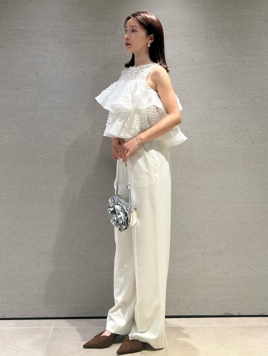 ホワイト系のスラックス、ホワイト系のシャツ/ブラウス、ブラウン系のパンプスを着用したレディースの春コーディネートの2枚目の写真