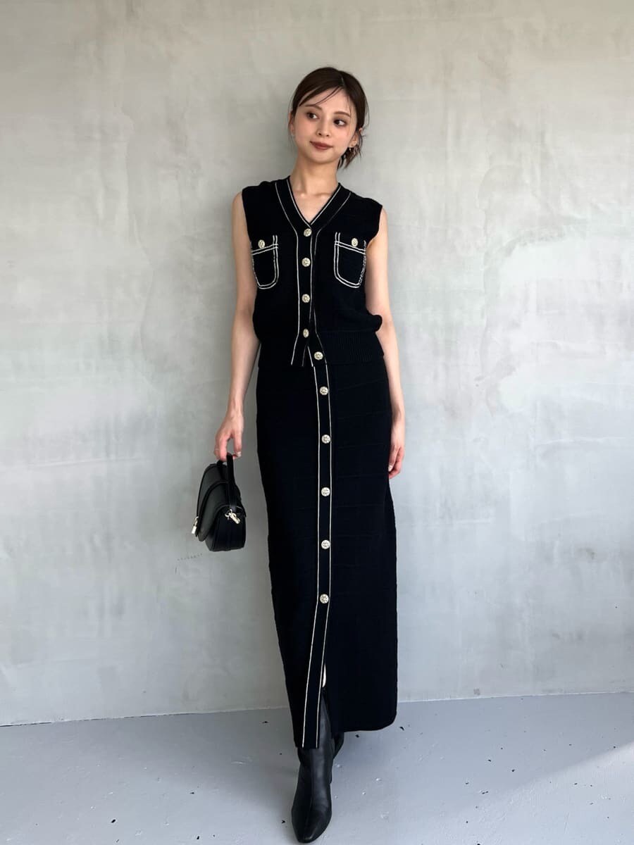 ブルー系のニット/セーター、ブルー系のスカート、ブラック系のハンドバッグを着用したレディースの夏コーディネートの2枚目の写真