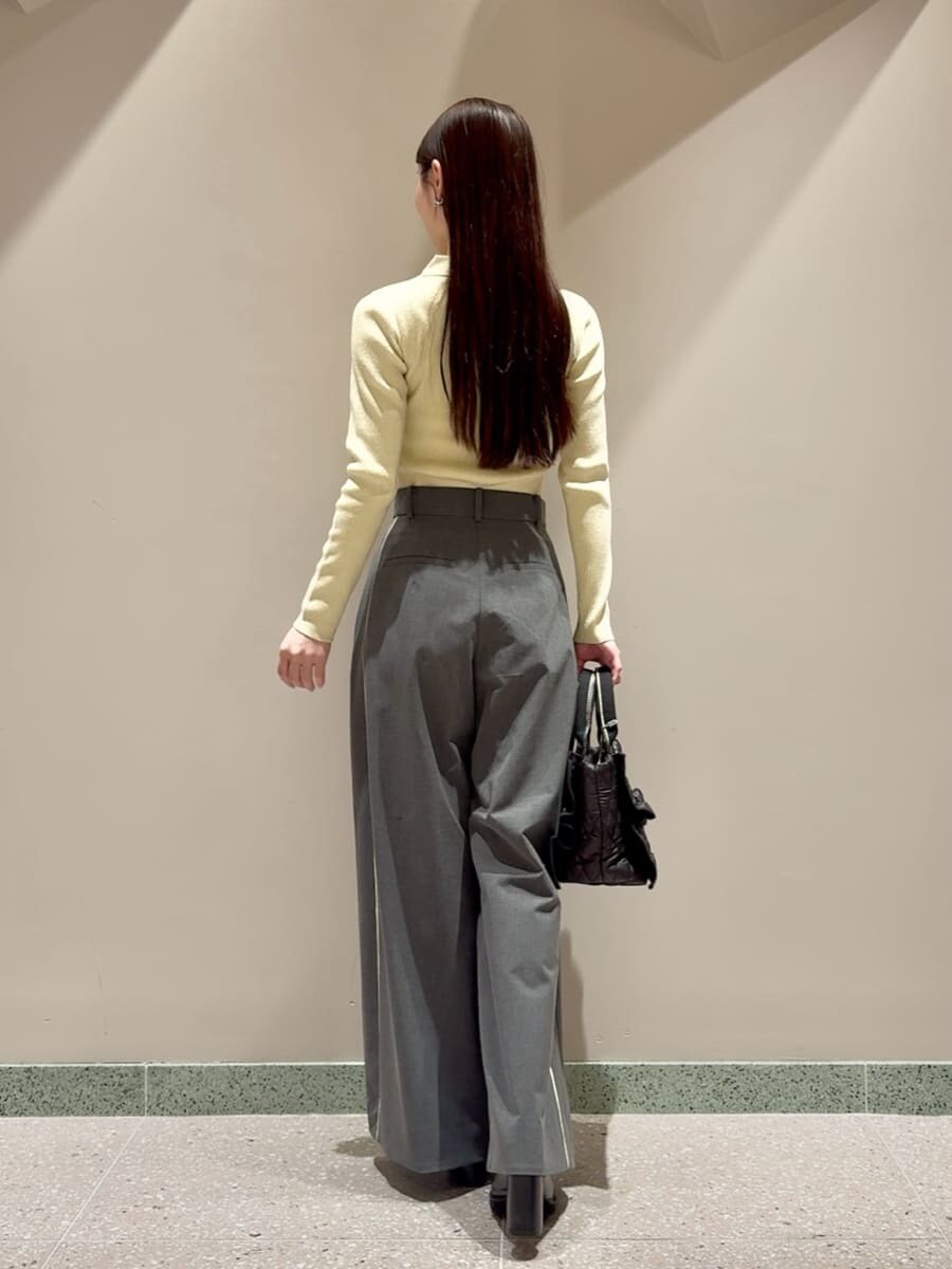 イエロー系のニット/セーター、グレー系のその他パンツ、ブラック系のローファーを着用したレディースの秋コーディネートの3枚目の写真