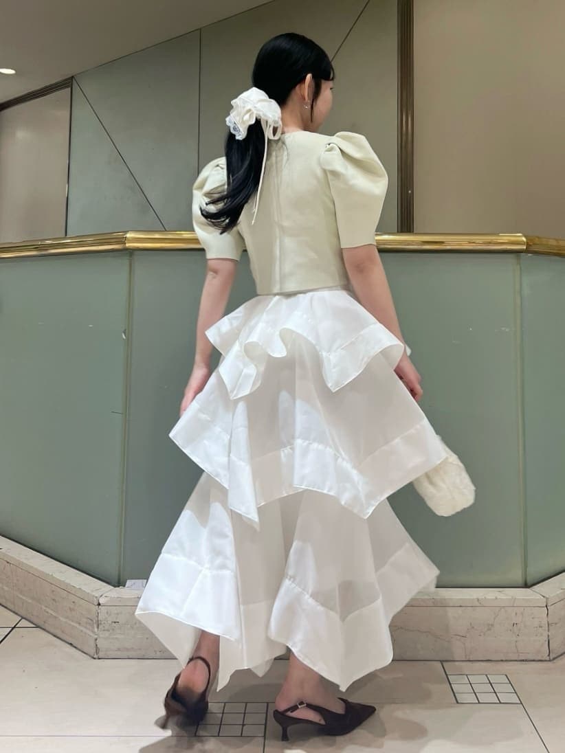 ホワイト系のスカート、イエロー系のカーディガン/ボレロ、ブラウン系のパンプスを着用したレディースの春コーディネートの5枚目の写真