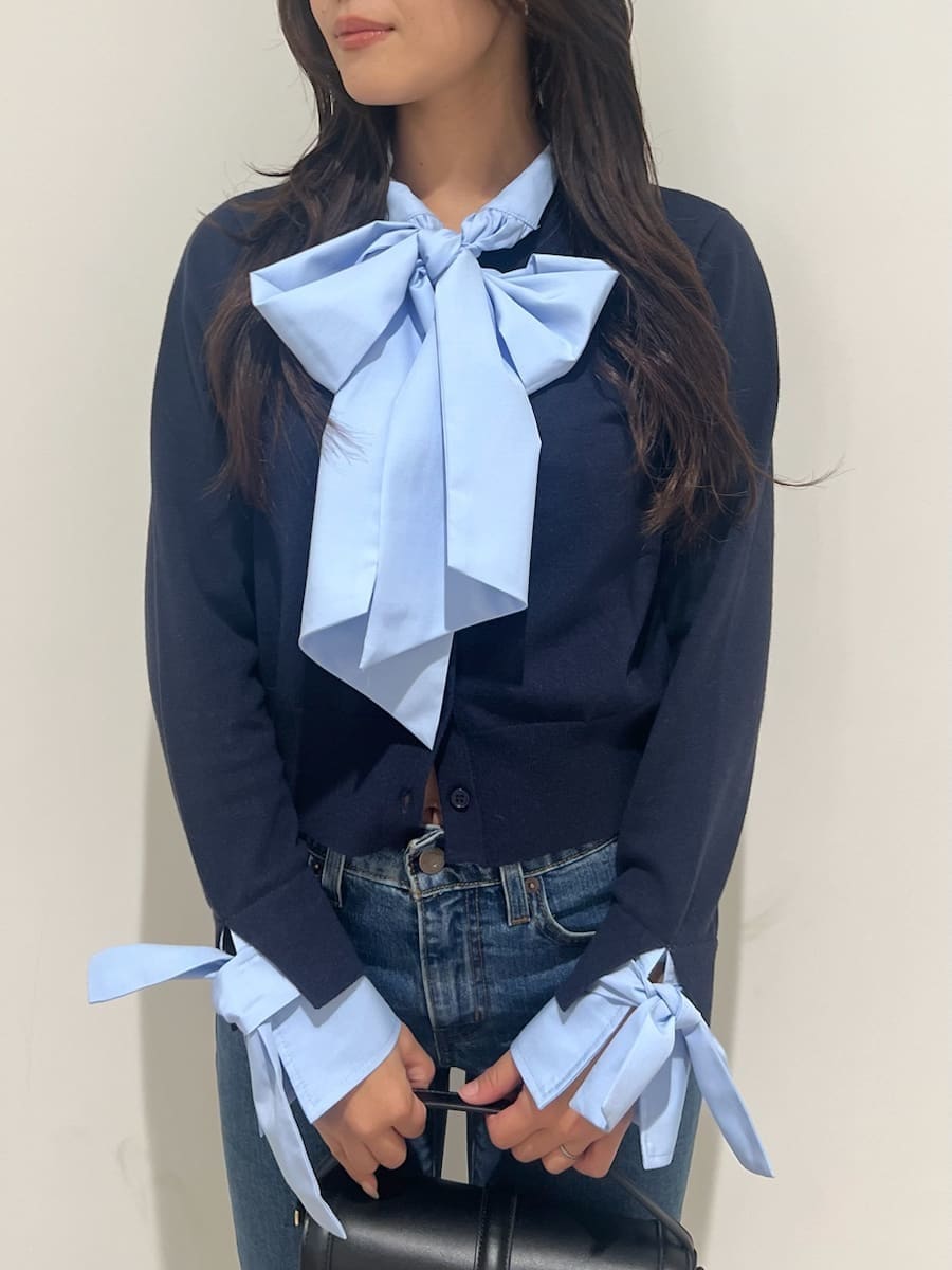 ブルー系のニット/セーター、ブルー系のデニムパンツ、ブラック系のブーツを着用したレディースの秋コーディネートの4枚目の写真