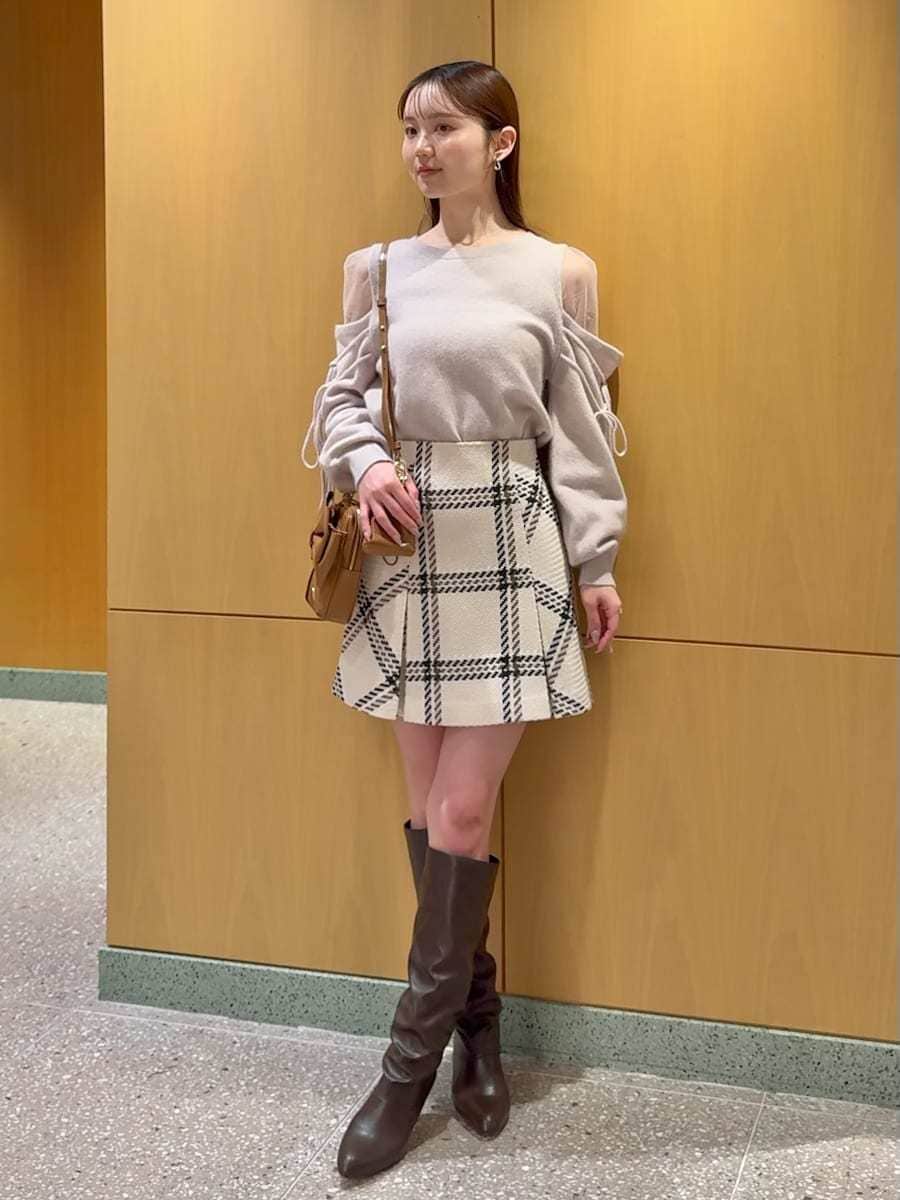 ホワイト系のスカート、ピンク系のニット/セーター、イエロー系のショルダーバッグを着用したレディースの冬コーディネートの2枚目の写真