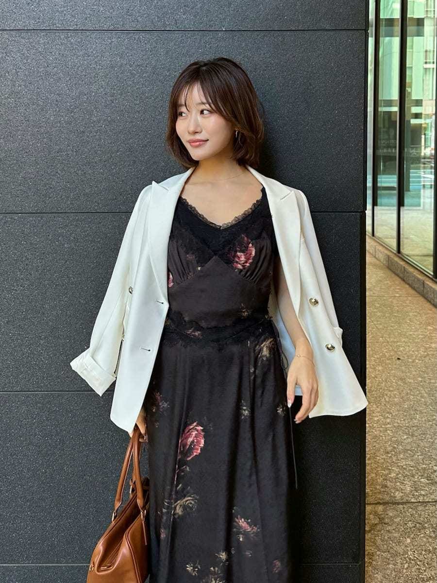 ブラック系のキャミソール、ホワイト系のテーラードジャケット、ブラック系のワンピースを着用したレディースの春コーディネートの7枚目の写真