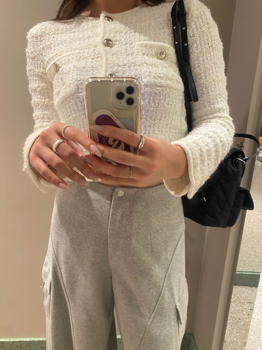 グレー系のその他パンツ、ホワイト系のカーディガン/ボレロ、ブラック系のブーツを着用したレディースの夏コーディネートの6枚目の写真
