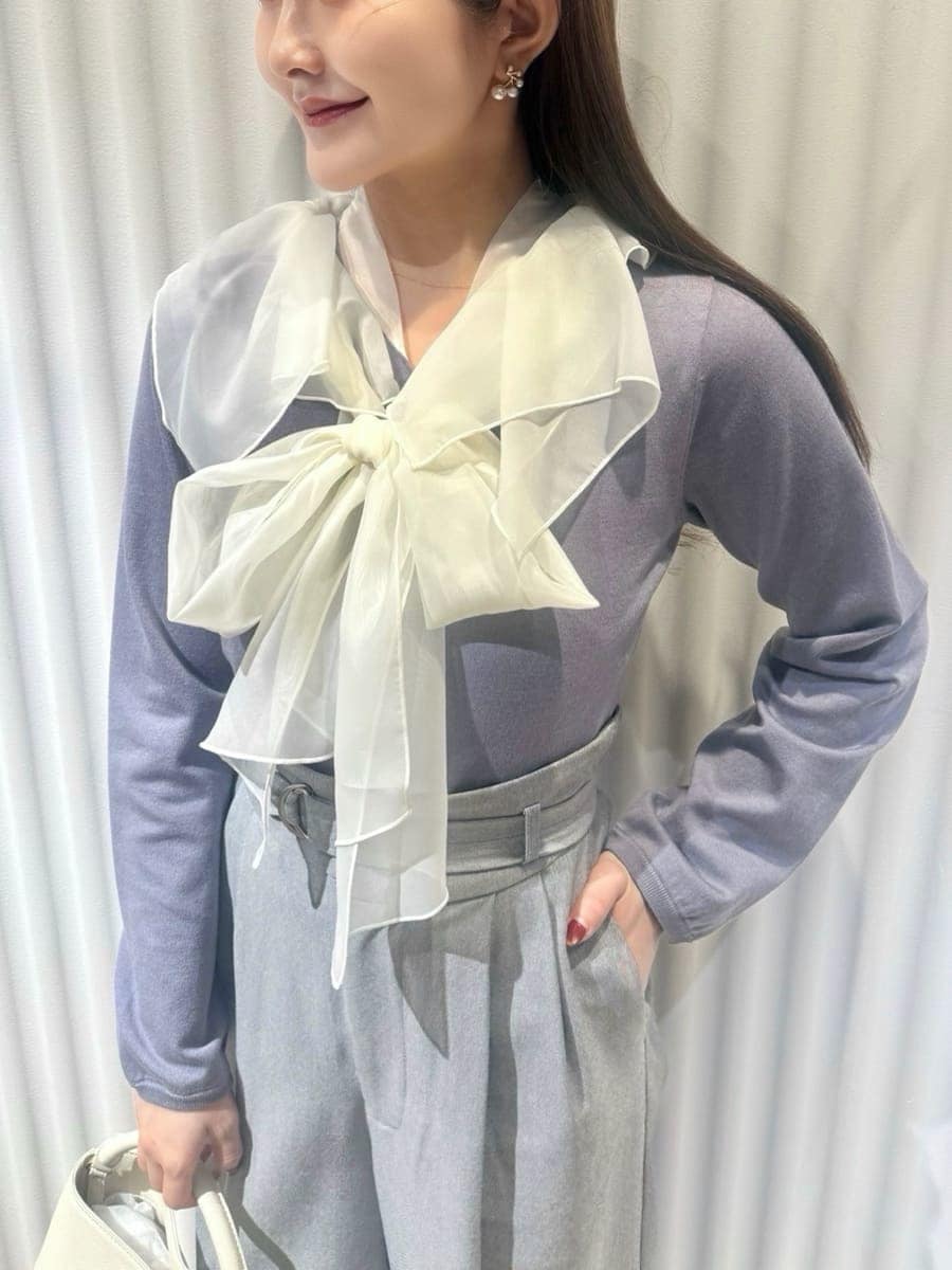 ブラック系のチェスターコート、ブルー系のニット/セーター、ホワイト系のハンドバッグを着用したレディースの冬コーディネートの8枚目の写真