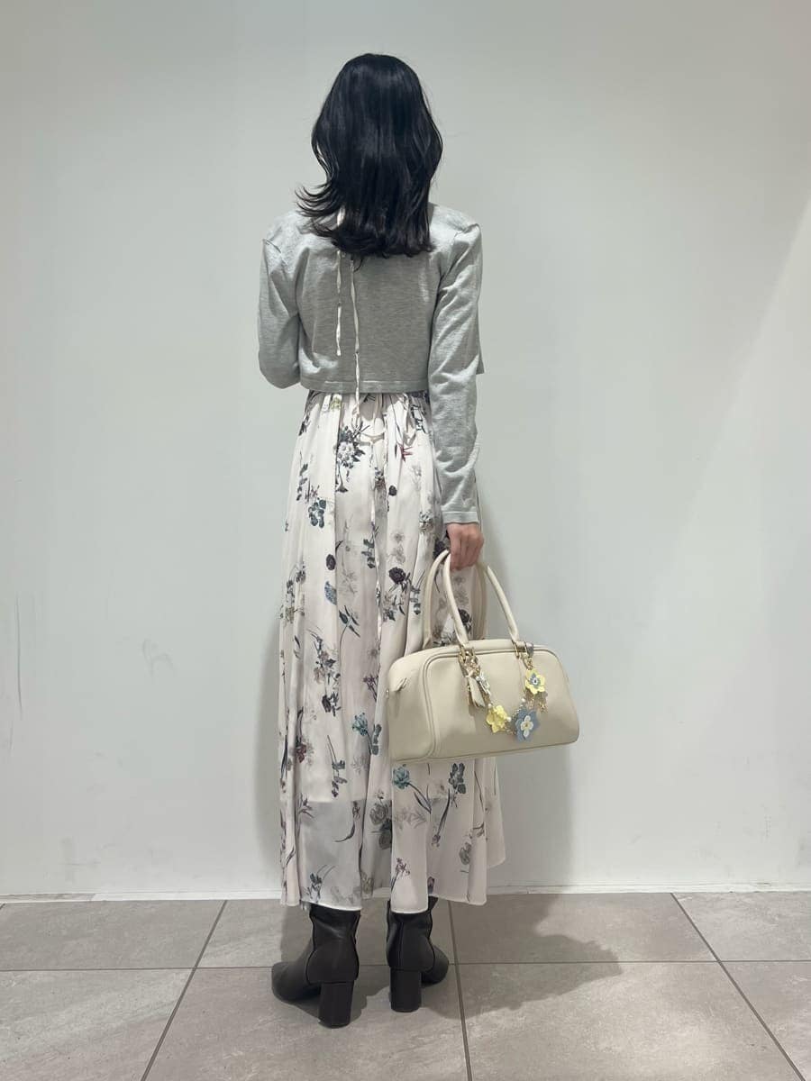 グレー系のブーツ、ホワイト系のワンピース、ホワイト系のボストンバッグを着用したレディースの冬コーディネートの3枚目の写真