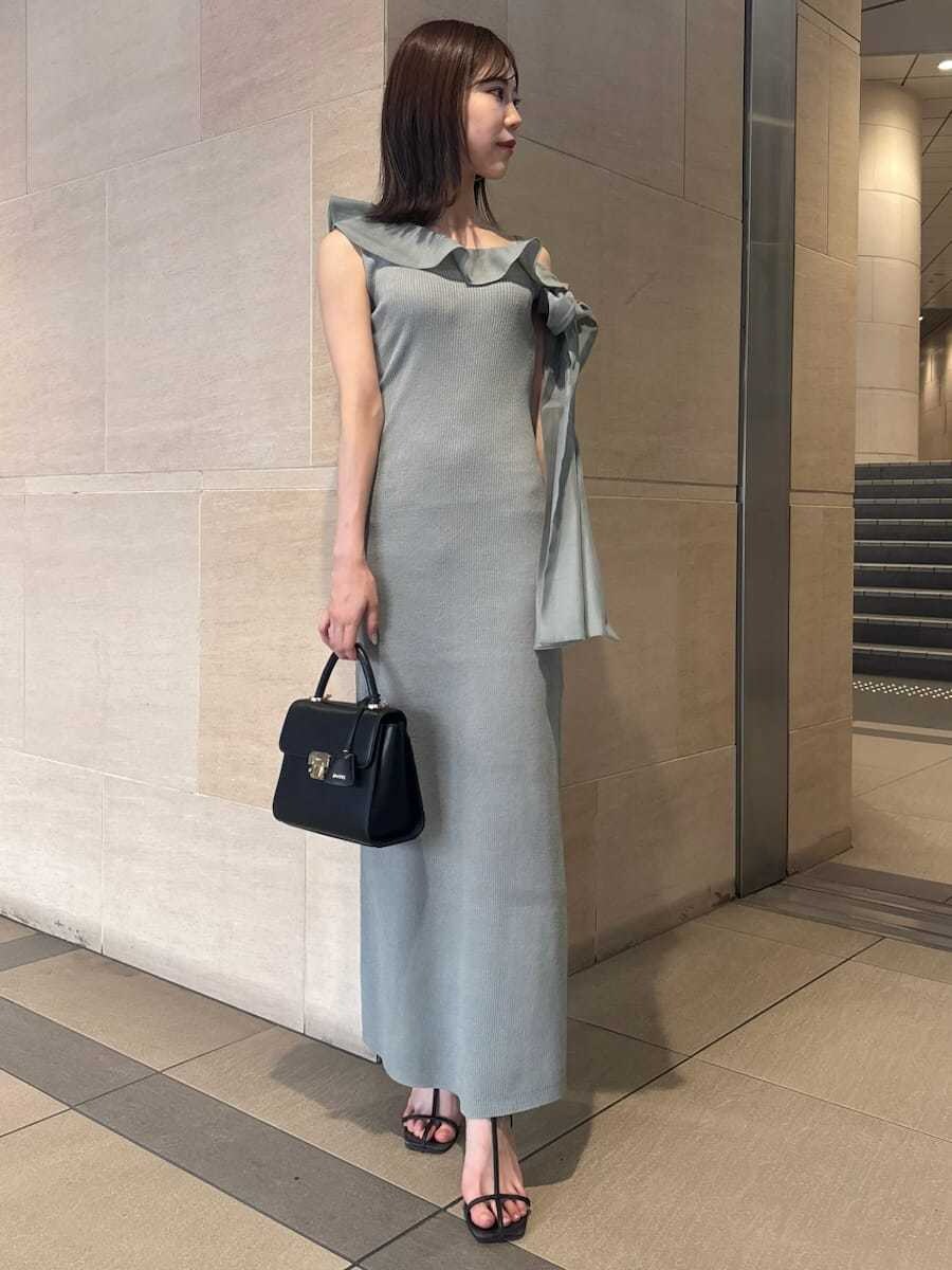 グリーン系のワンピース、ブラック系のサンダル、ブラック系のショルダーバッグを着用したレディースの夏コーディネートの2枚目の写真