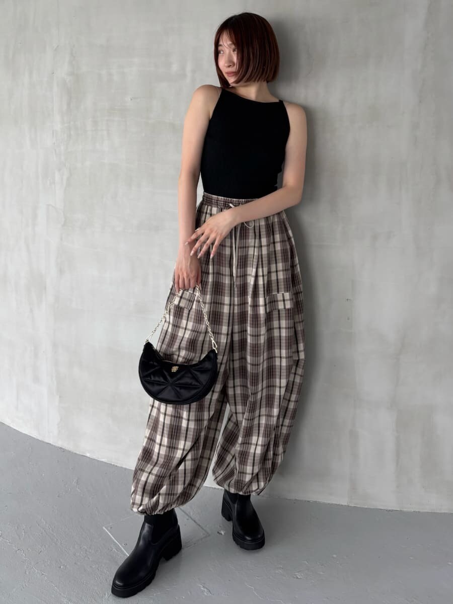 ブラック系のニット/セーター、ベージュ系のその他パンツ、ブラック系のショルダーバッグを着用したレディースの夏コーディネートの5枚目の写真