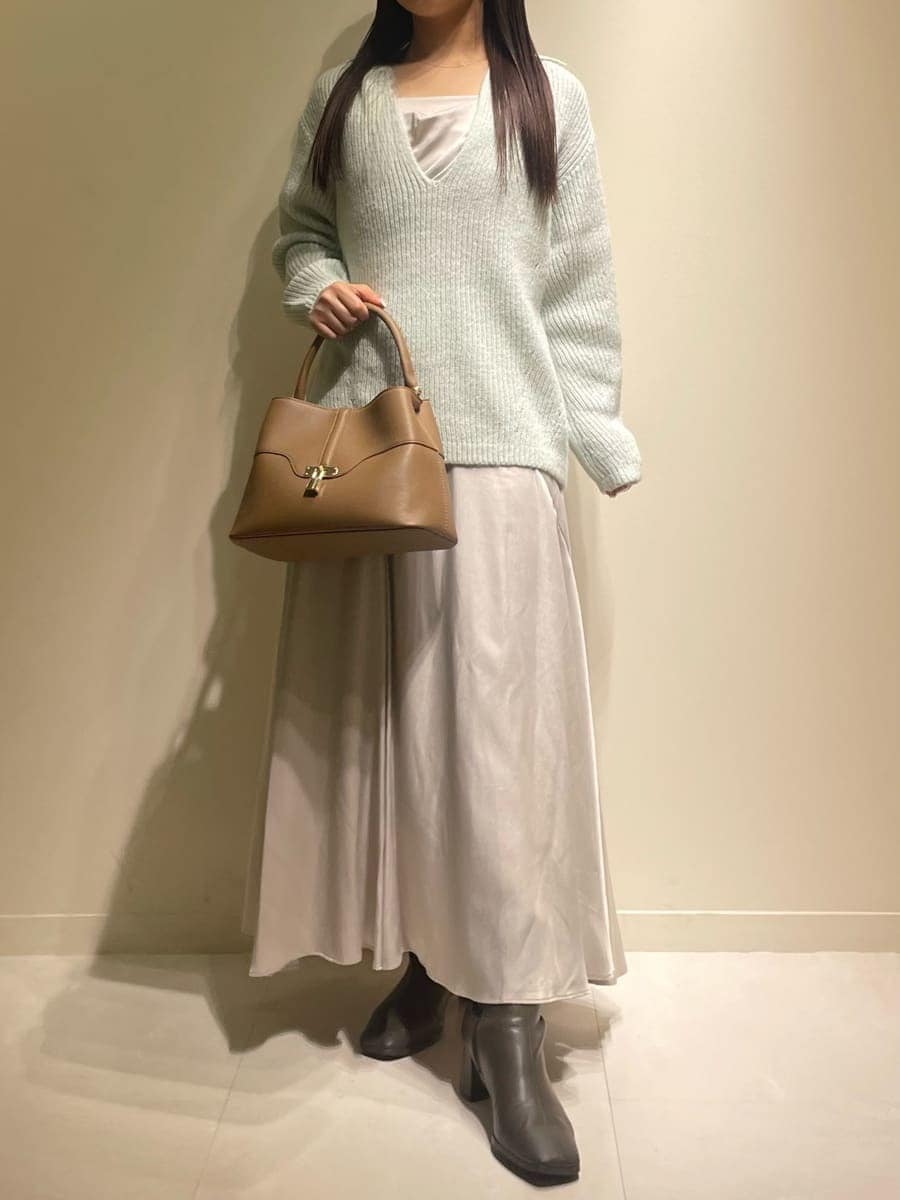 グリーン系のワンピース、イエロー系のハンドバッグを着用したレディースの冬コーディネートの2枚目の写真