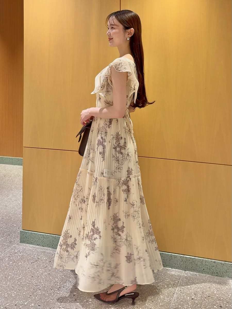 ブラウン系のハンドバッグ、イエロー系のワンピースを着用したレディースの夏コーディネートの2枚目の写真