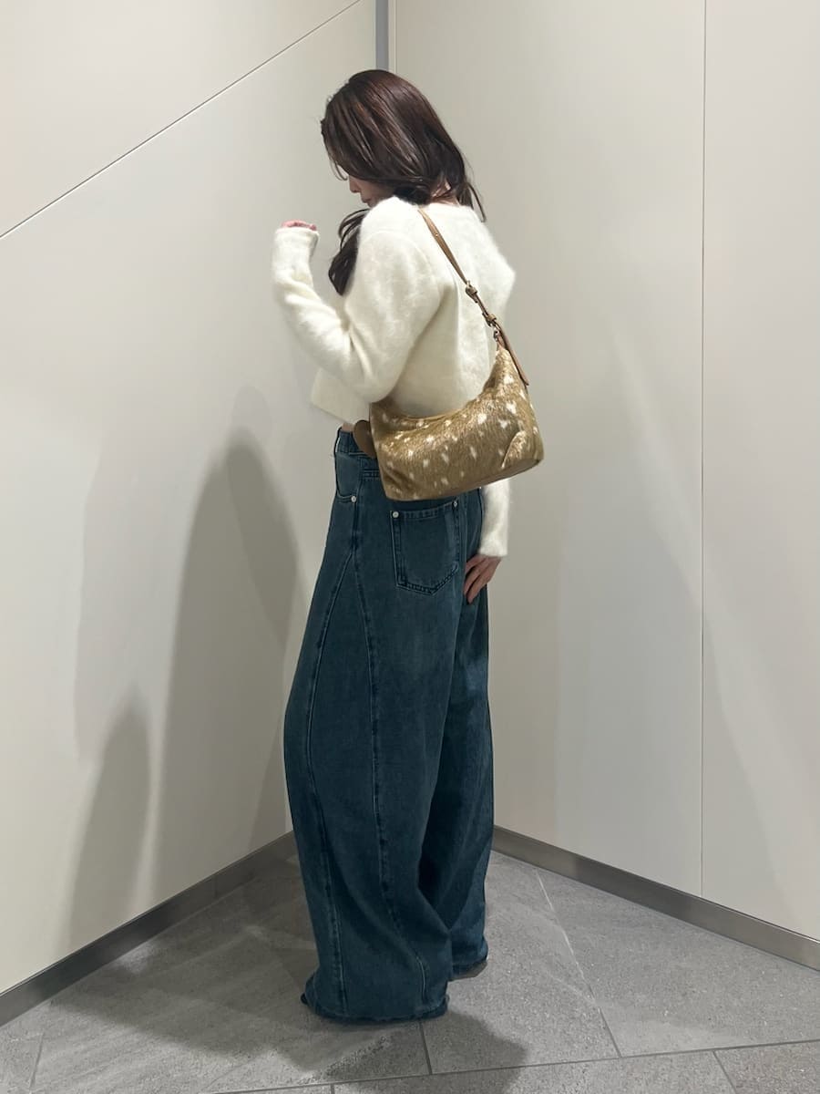ホワイト系のノーカラージャケット、ブルー系のデニムパンツ、ホワイト系のキャミソールを着用したレディースの秋コーディネートの2枚目の写真