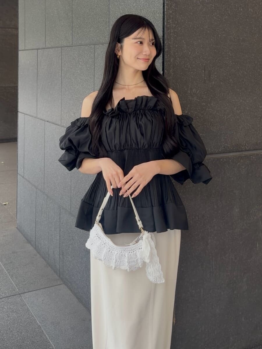 ホワイト系のスカート、ブラック系のその他トップス、ブラック系のパンプスを着用したレディースの春コーディネートの5枚目の写真