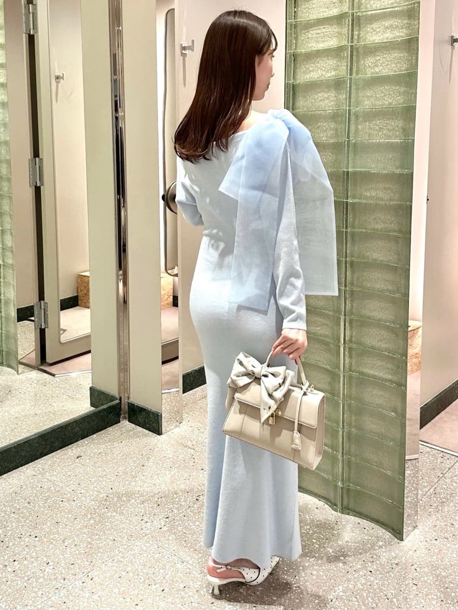 ブルー系のワンピース、その他のパンプス、ベージュ系のハンドバッグを着用したレディースの冬コーディネートの4枚目の写真