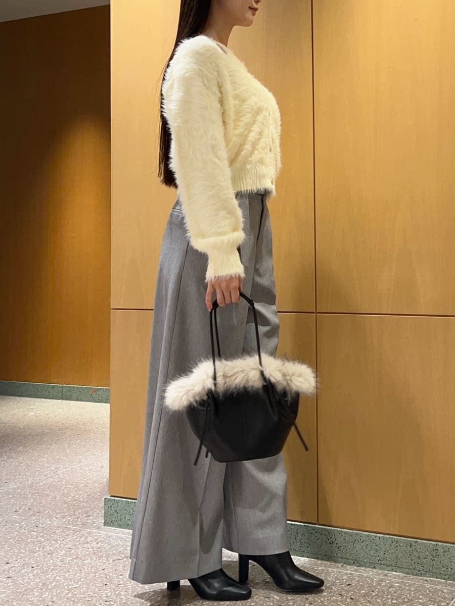 ブラック系のブーツ、イエロー系のニット/セーター、ブラック系のハンドバッグを着用したレディースの秋コーディネートの4枚目の写真