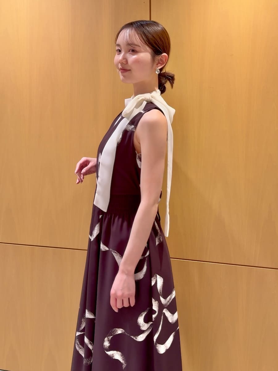 ホワイト系のショルダーバッグ、ブラウン系のワンピース、シルバー系のピアス（両耳用）を着用したレディースの冬コーディネートの5枚目の写真