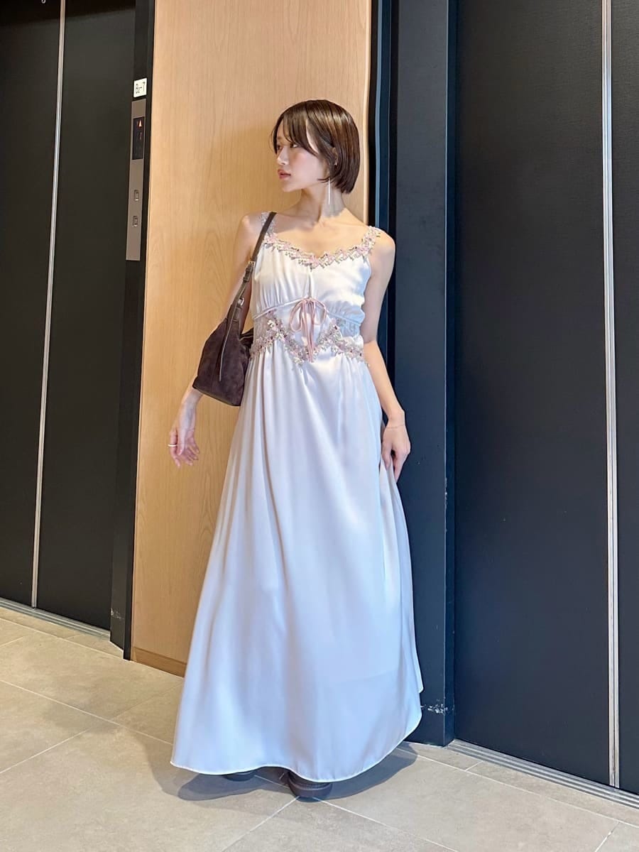 ピンク系のワンピース、ブラウン系のブーツ、ブラウン系のショルダーバッグを着用したレディースの夏コーディネートの3枚目の写真