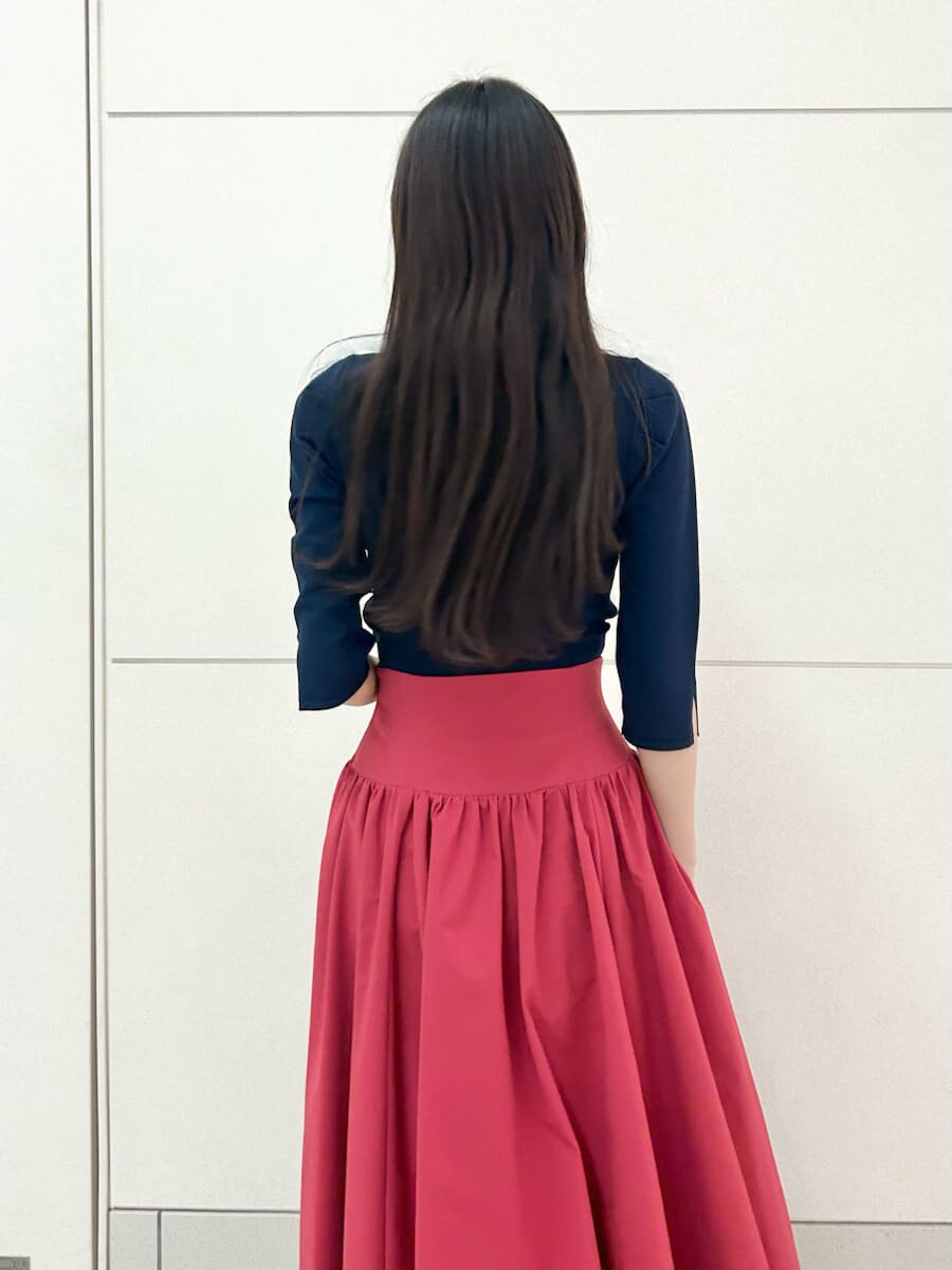 ブラック系のブーツ、ブルー系のニット/セーター、レッド系のスカートを着用したレディースの冬コーディネートの7枚目の写真