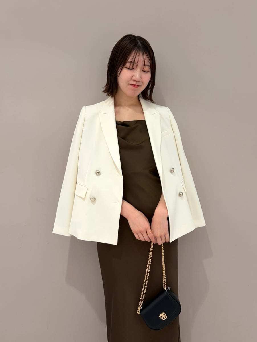 ホワイト系のテーラードジャケット、ブラック系のパンプス、ブラック系のショルダーバッグを着用したレディースの春コーディネートの3枚目の写真