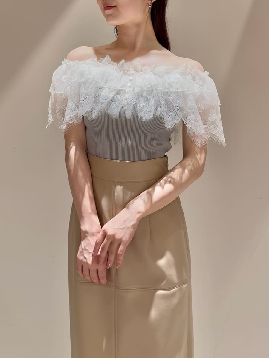 グリーン系のニット/セーター、ホワイト系のスカート、ブラック系のローファーを着用したレディースの夏コーディネートの4枚目の写真