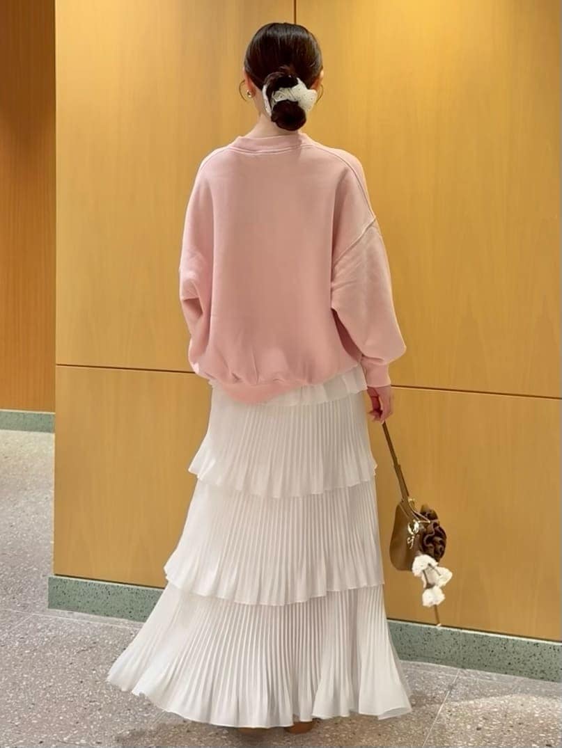 ホワイト系のスカート、ピンク系のスウェット、ブラウン系のハンドバッグを着用したレディースの春コーディネートの4枚目の写真