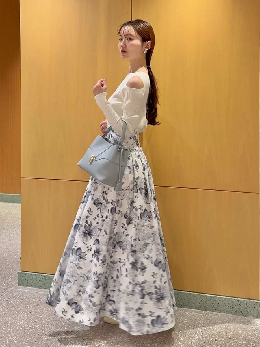 ブルー系のショルダーバッグ、ホワイト系のニット/セーターを着用したレディースの冬コーディネートの2枚目の写真