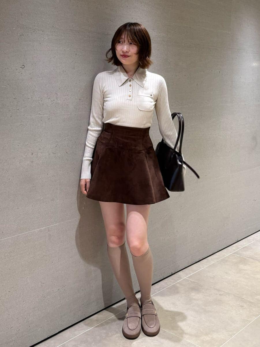 ブラウン系のその他パンツ、ベージュ系のポロシャツ、ブラック系のボストンバッグを着用したレディースの秋コーディネートの3枚目の写真