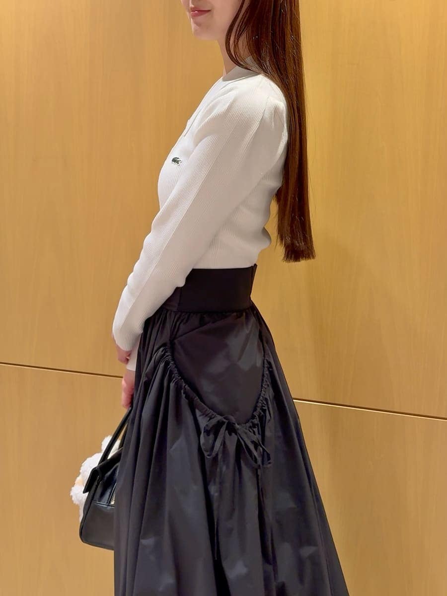 ホワイト系のニット/セーター、ブラック系のスカート、その他のブーツを着用したレディースの秋コーディネートの6枚目の写真