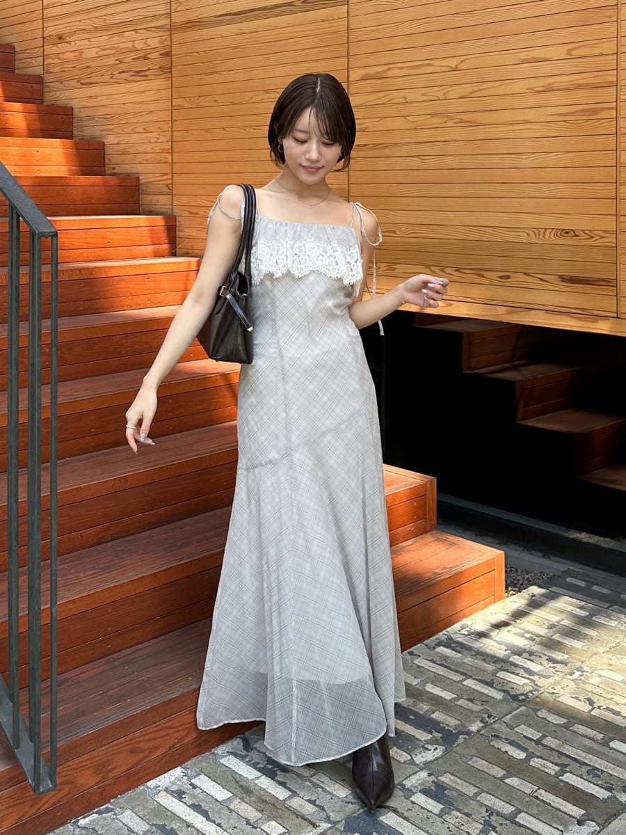 ベージュ系のワンピース、ブラウン系のブーツ、ブラウン系のボストンバッグを着用したレディースの夏コーディネートの7枚目の写真