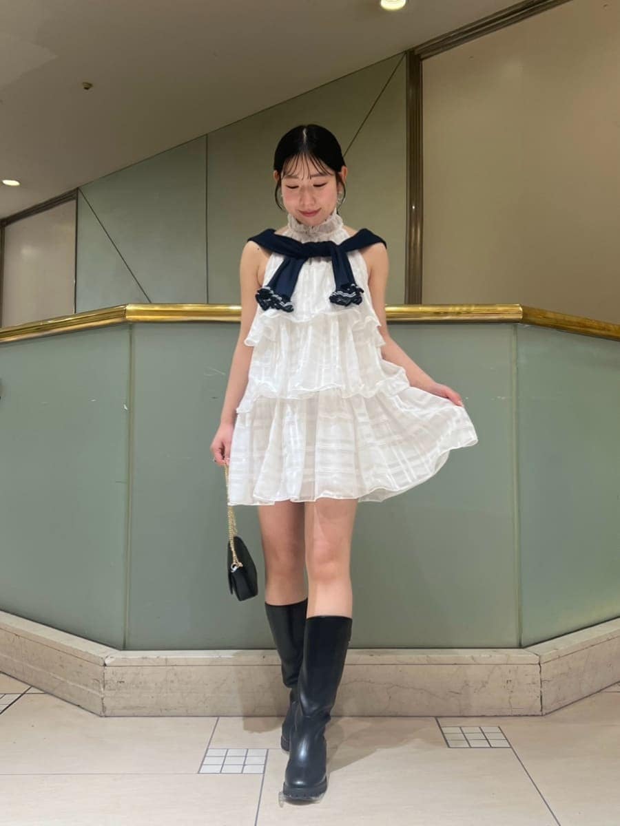 ホワイト系のワンピース、ブルー系のカーディガン/ボレロ、ブラック系のショルダーバッグを着用したレディースの春コーディネートの2枚目の写真