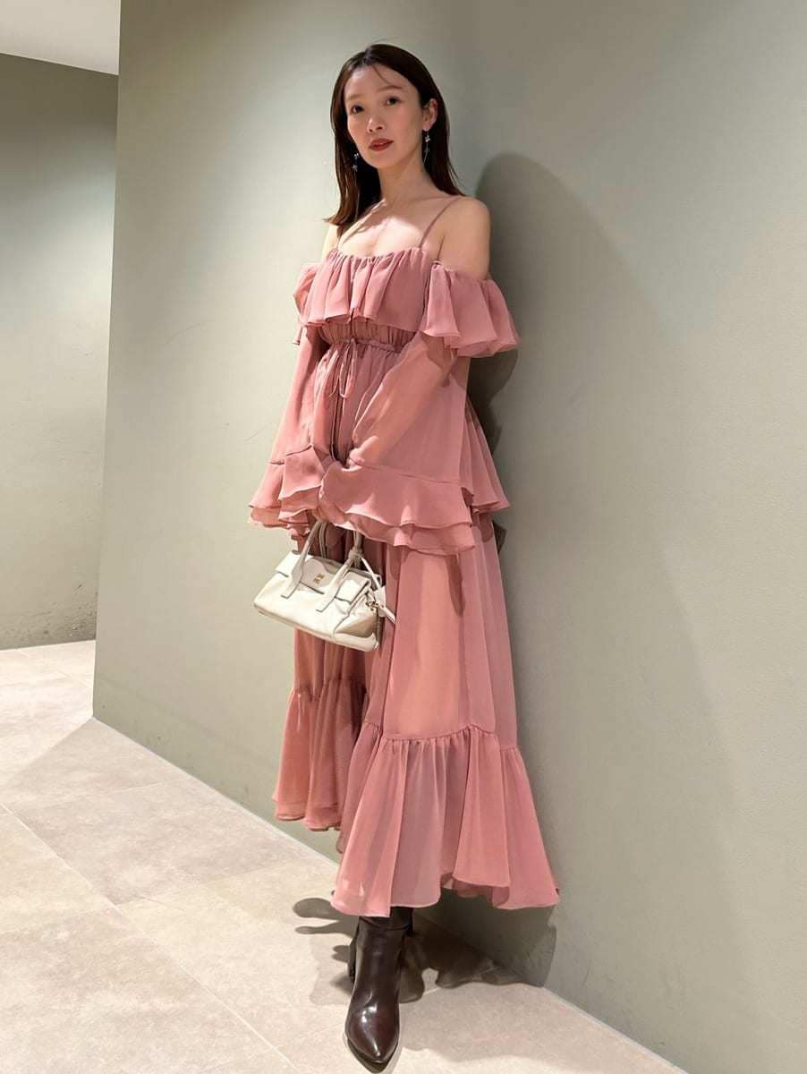 ブラウン系のブーツ、オレンジ系のワンピース、ホワイト系のボストンバッグを着用したレディースの冬コーディネートの4枚目の写真