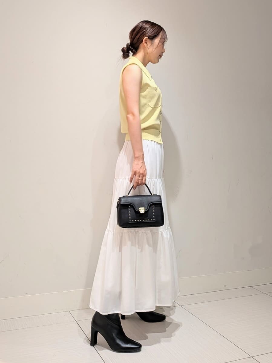 グリーン系のワンピース、ブラック系のブーツ、ブラック系のショルダーバッグを着用したレディースの夏コーディネートの2枚目の写真