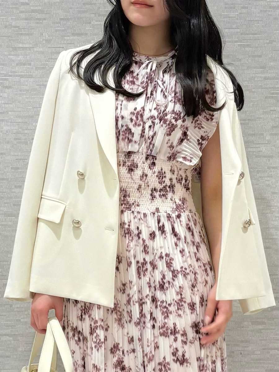 ピンク系のワンピース、ホワイト系のテーラードジャケット、ホワイト系のハンドバッグを着用したレディースの冬コーディネートの3枚目の写真