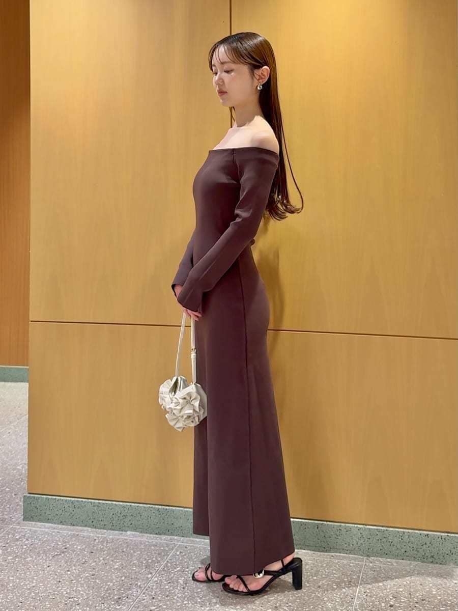 ホワイト系のハンドバッグ、ブラウン系のワンピースを着用したレディースの春コーディネートの2枚目の写真