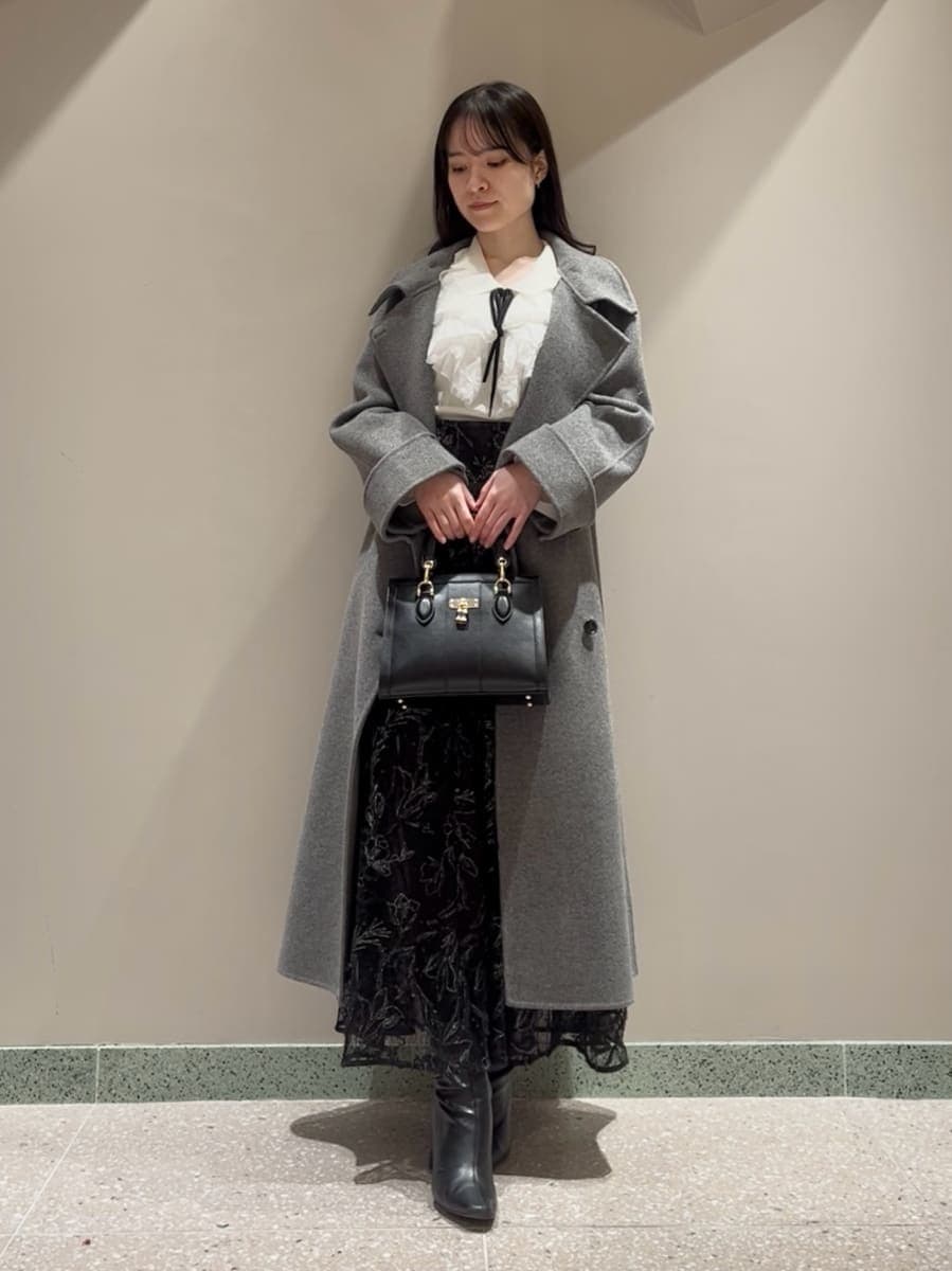 ブラック系のブーツ、グレー系のチェスターコート、ブラック系のスカートを着用したレディースの冬コーディネートの3枚目の写真