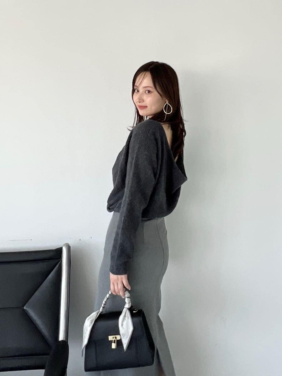 グレー系のワンピース、ブラック系のハンドバッグを着用したレディースの秋コーディネートの3枚目の写真
