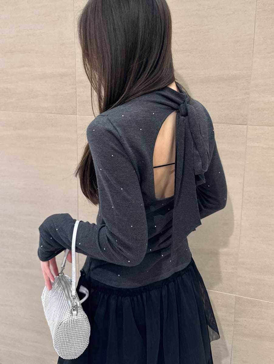 ブラック系のブーツ、ブラック系のスカート、グレー系のニット/セーターを着用したレディースの冬コーディネートの7枚目の写真