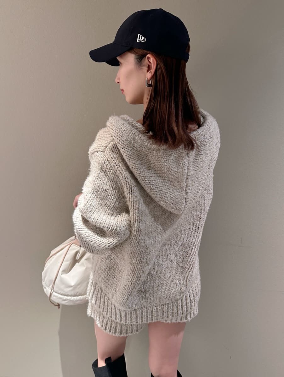 ホワイト系のその他パンツ、ホワイト系のニット/セーター、ベージュ系のハンドバッグを着用したレディースの夏コーディネートの5枚目の写真