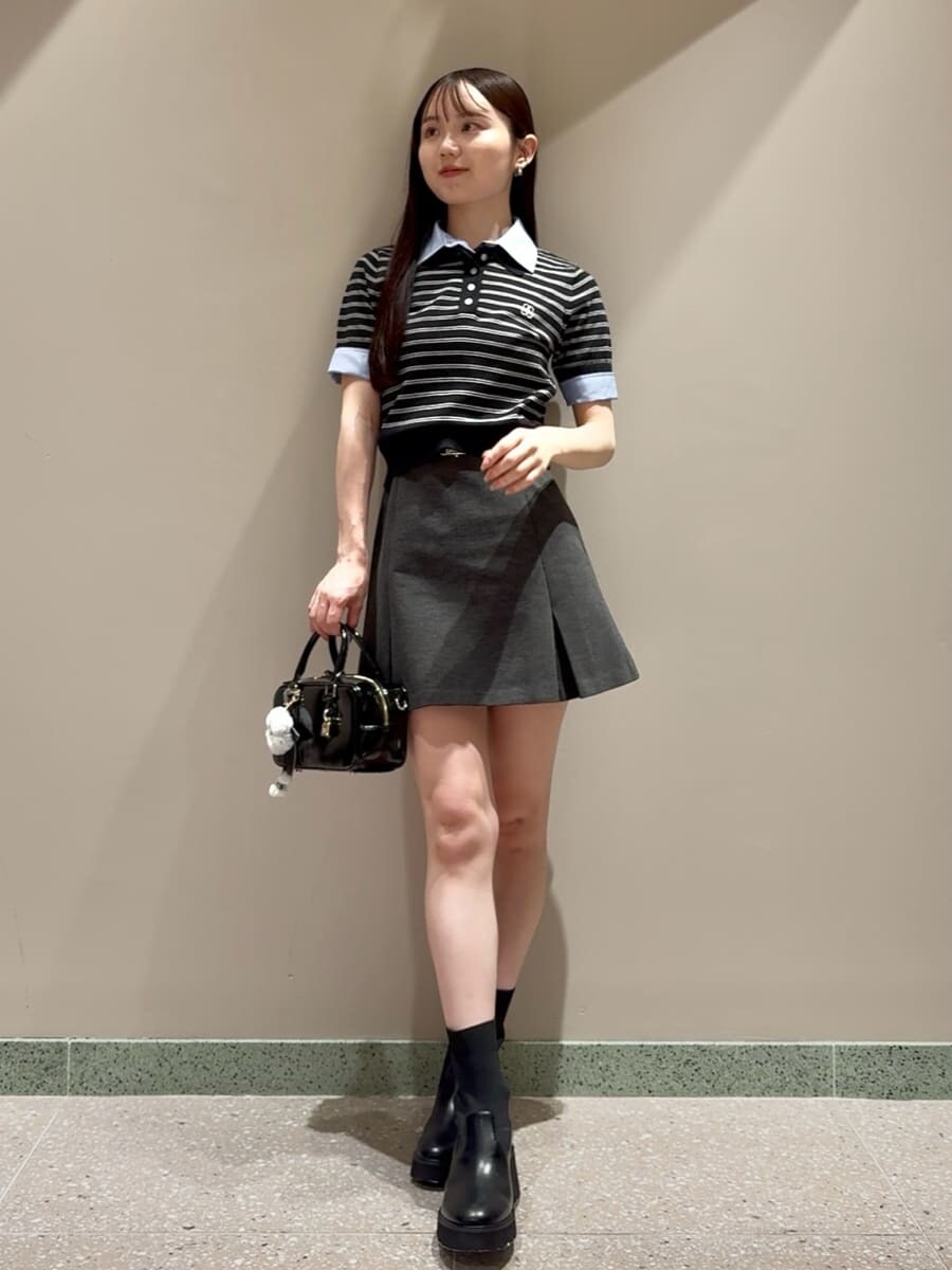 ブルー系のニット/セーター、グレー系のスカート、ブラック系のボストンバッグを着用したレディースの夏コーディネートの2枚目の写真