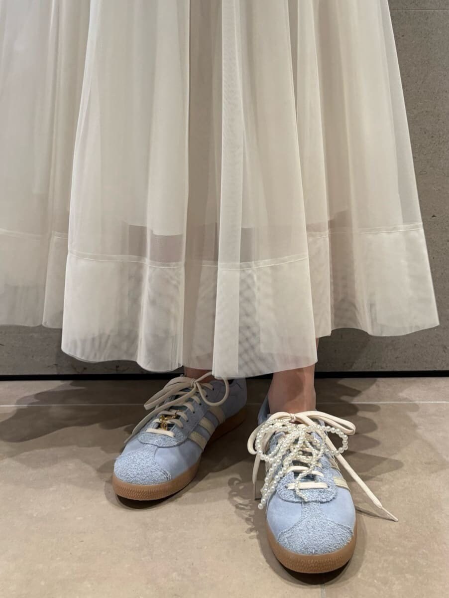 ブラック系のニット/セーター、ホワイト系のスカートを着用したレディースの秋コーディネートの5枚目の写真