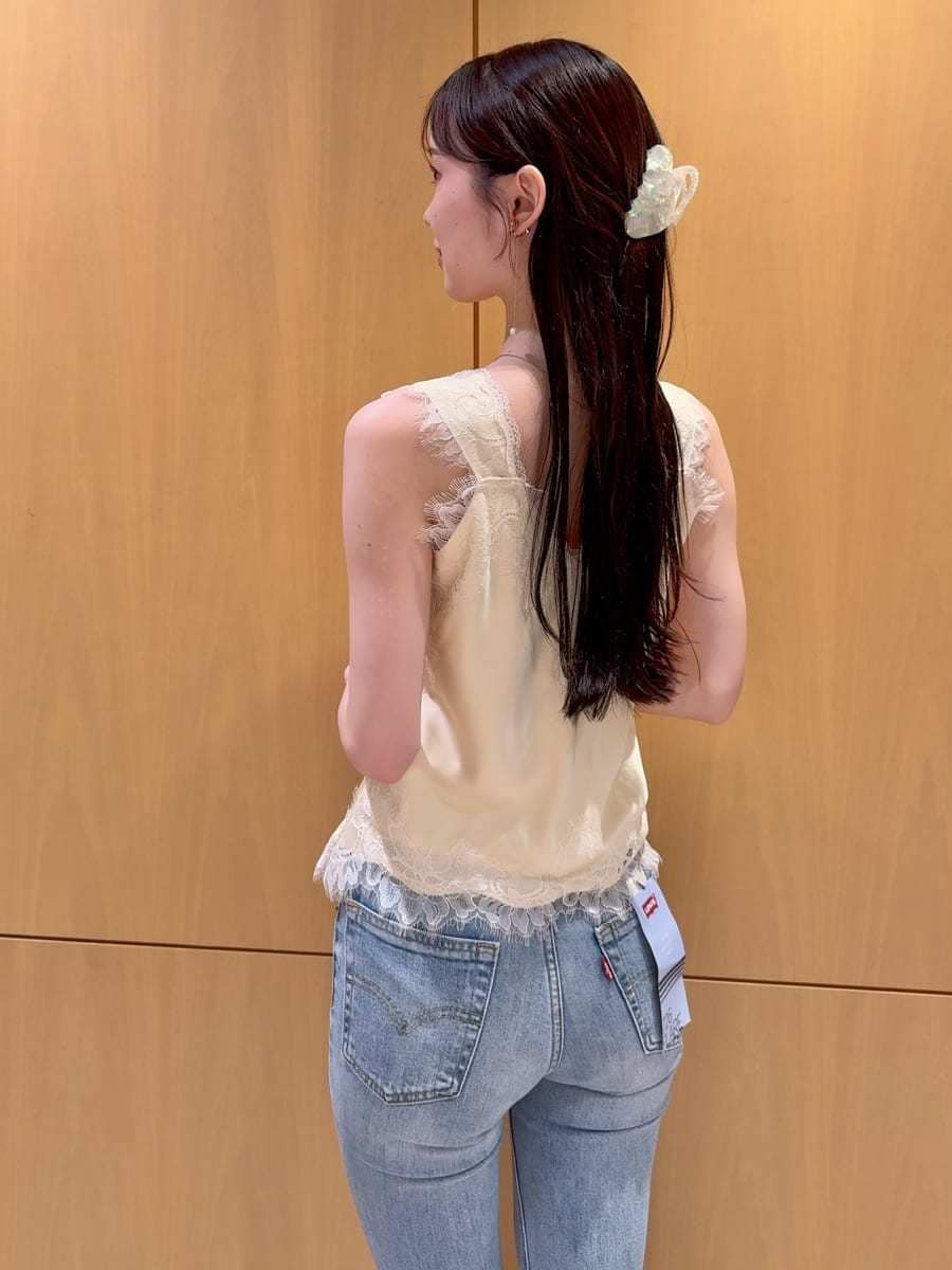 ブルー系のデニムパンツ、イエロー系のキャミソール、その他のイヤリングを着用したレディースの夏コーディネートの5枚目の写真