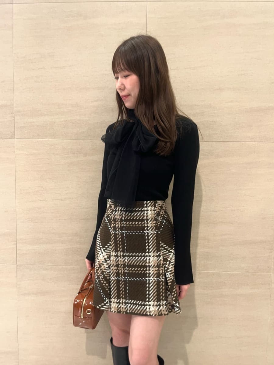 ブラック系のニット/セーター、ブラウン系のスカート、イエロー系のボストンバッグを着用したレディースの秋コーディネートの4枚目の写真