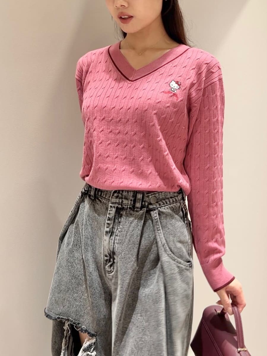 ピンク系のニット/セーター、グレー系のデニムパンツ、ブラウン系のショルダーバッグを着用したレディースの秋コーディネートの6枚目の写真