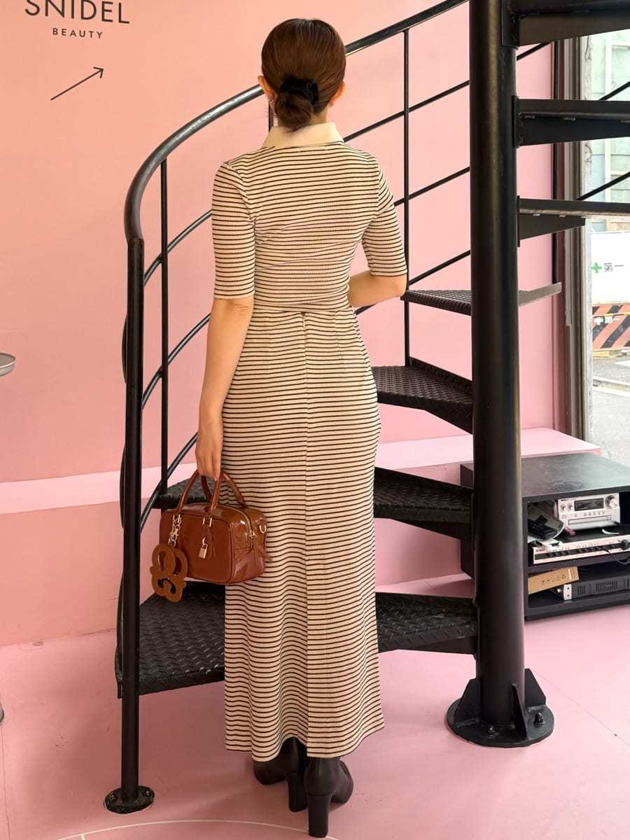 ホワイト系のワンピース、ブラック系のブーツ、ブラウン系のボストンバッグを着用したレディースの秋コーディネートの2枚目の写真