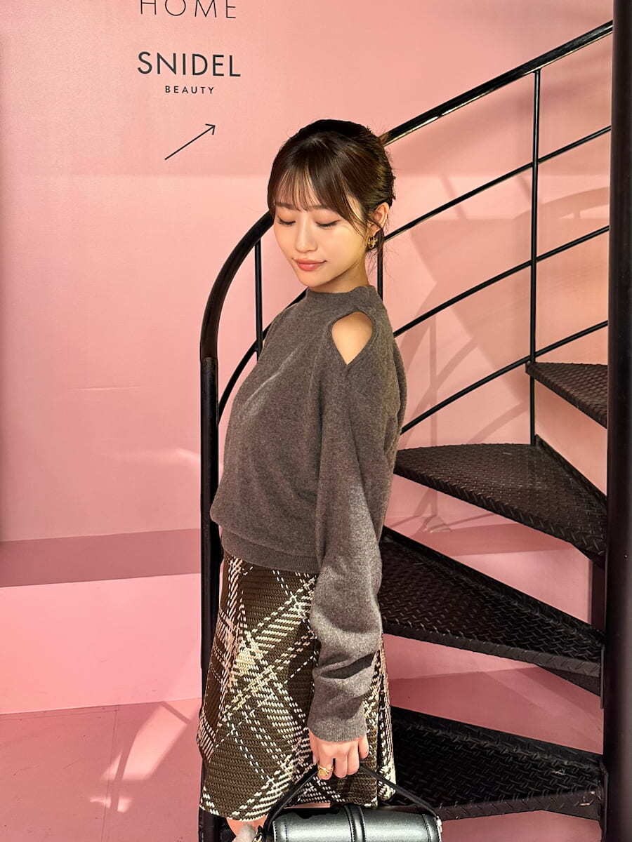 ブラウン系のニット/セーター、ブラウン系のスカート、グレー系のブーツを着用したレディースの秋コーディネートの5枚目の写真