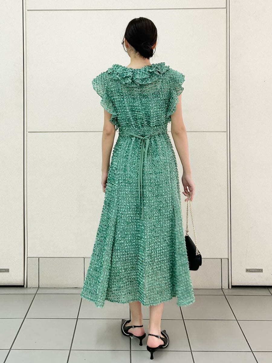 グリーン系のドレス、ブラック系のパンプス、ブラック系のショルダーバッグを着用したレディースの春コーディネートの4枚目の写真