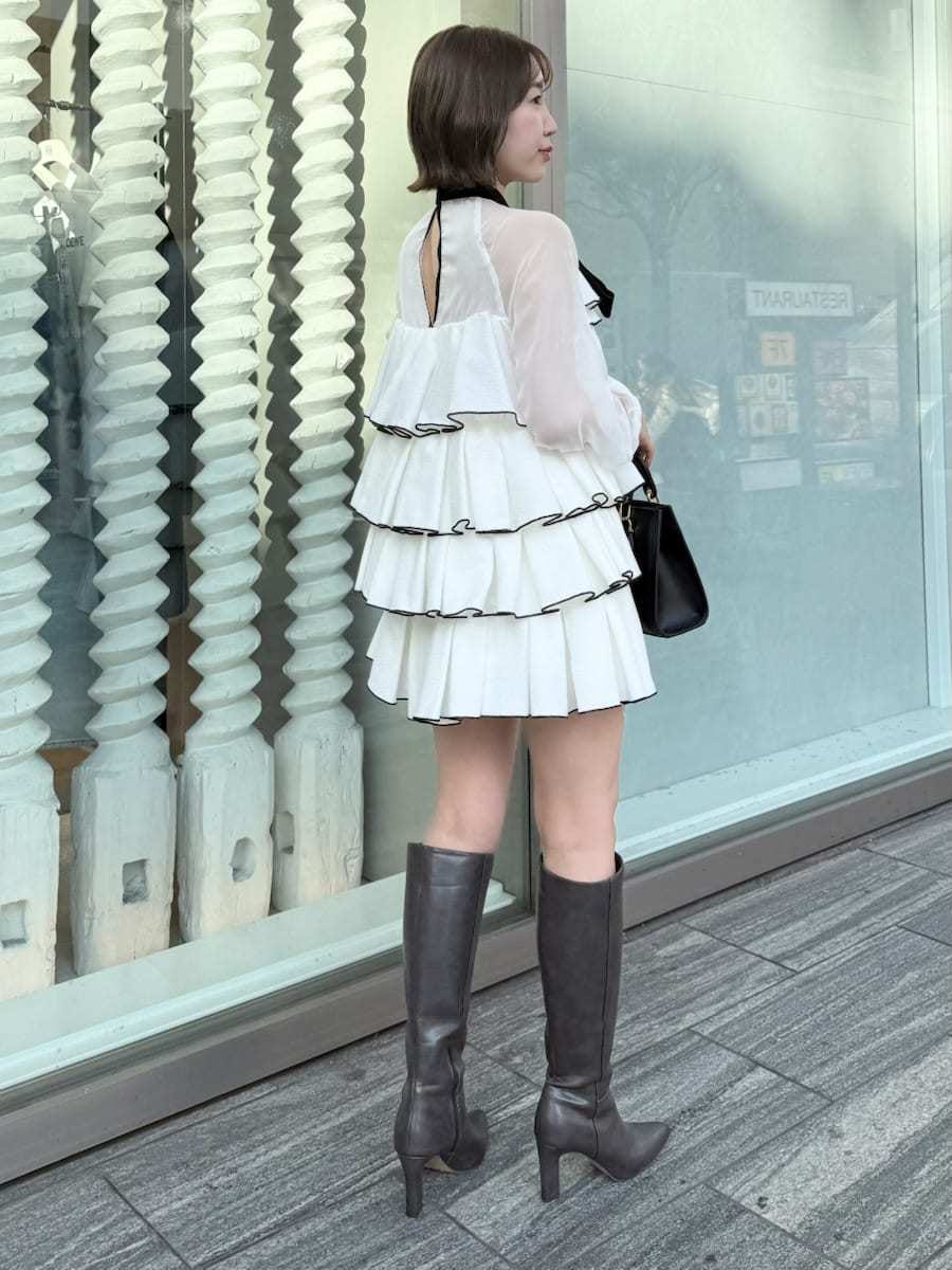 ホワイト系のドレス、ブラック系のハンドバッグを着用したレディースの冬コーディネートの10枚目の写真